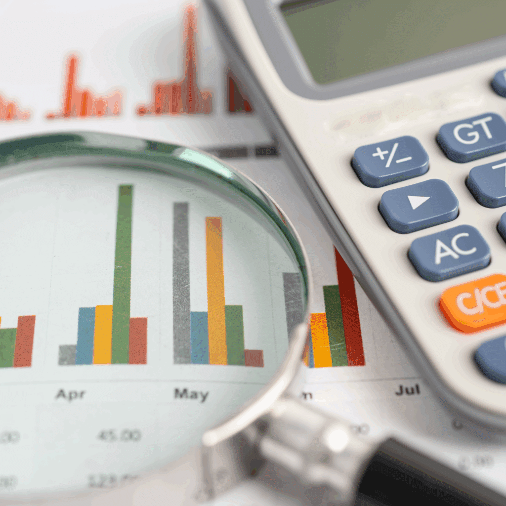 a calculator and magnifying glass on top of a stock market report