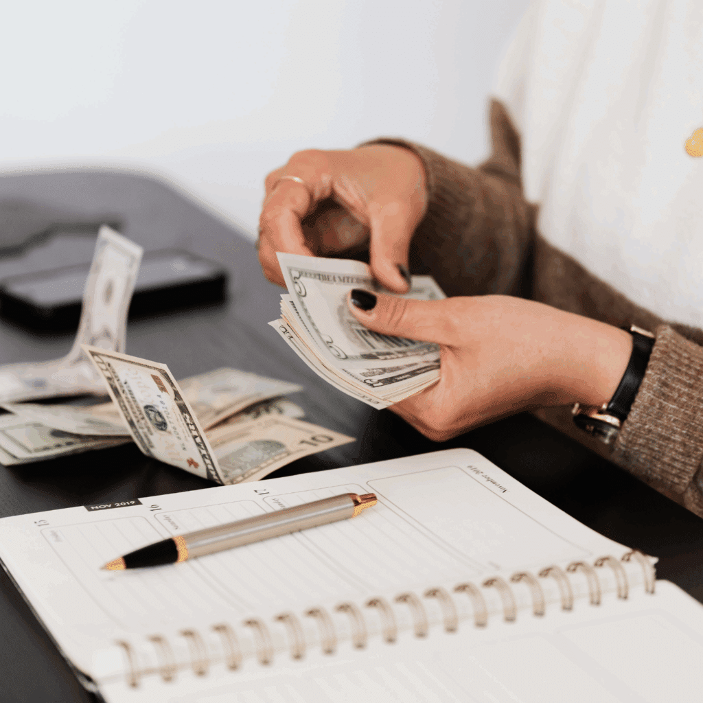 Woman creating a personal budget with a notebook and calculator at home.